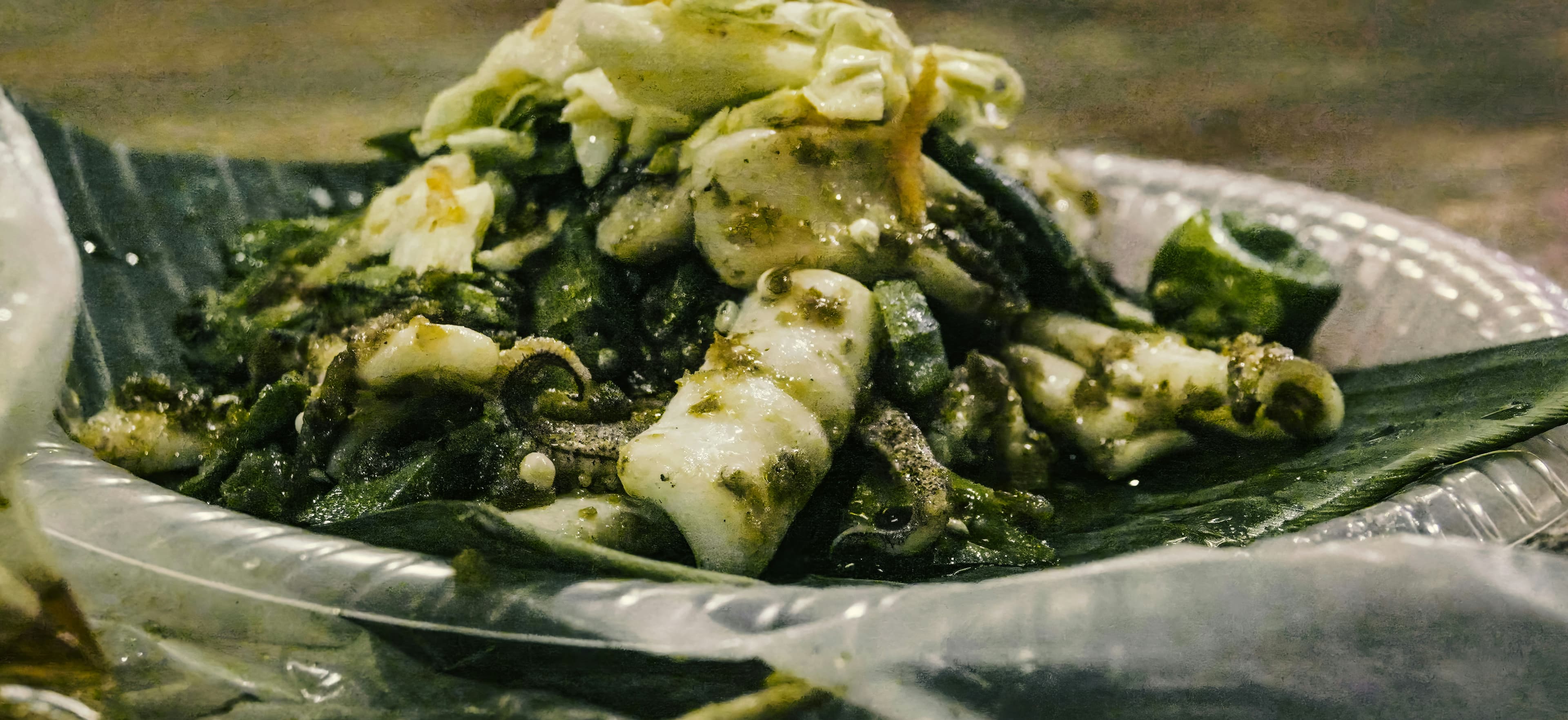 Traditional Pacific seafood wrapped in banana leaf — squid and greens dressed in a herb sauce